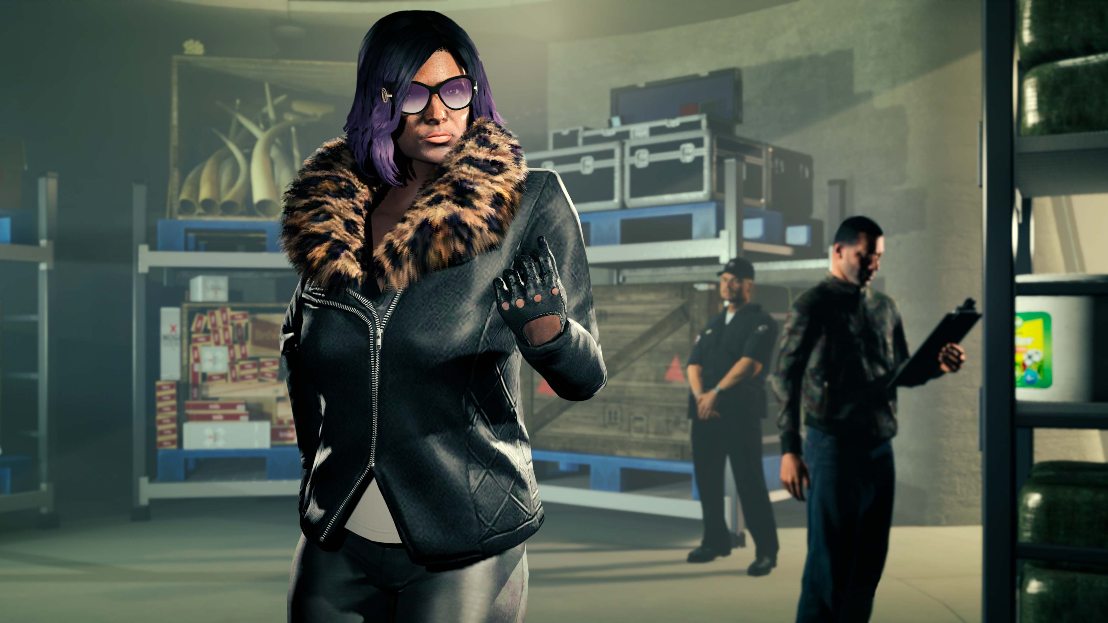 A GTA Online character stands in a Nightclub Warehouse wearing a leather jacket with fur trim. Two characters manage cargo in the background. 
