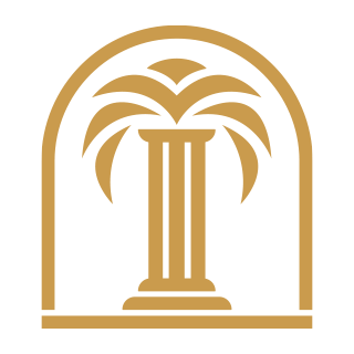 A golden emblem featuring a flat base and a tall arch containing a tall column with leaves resembling a palm tree. 