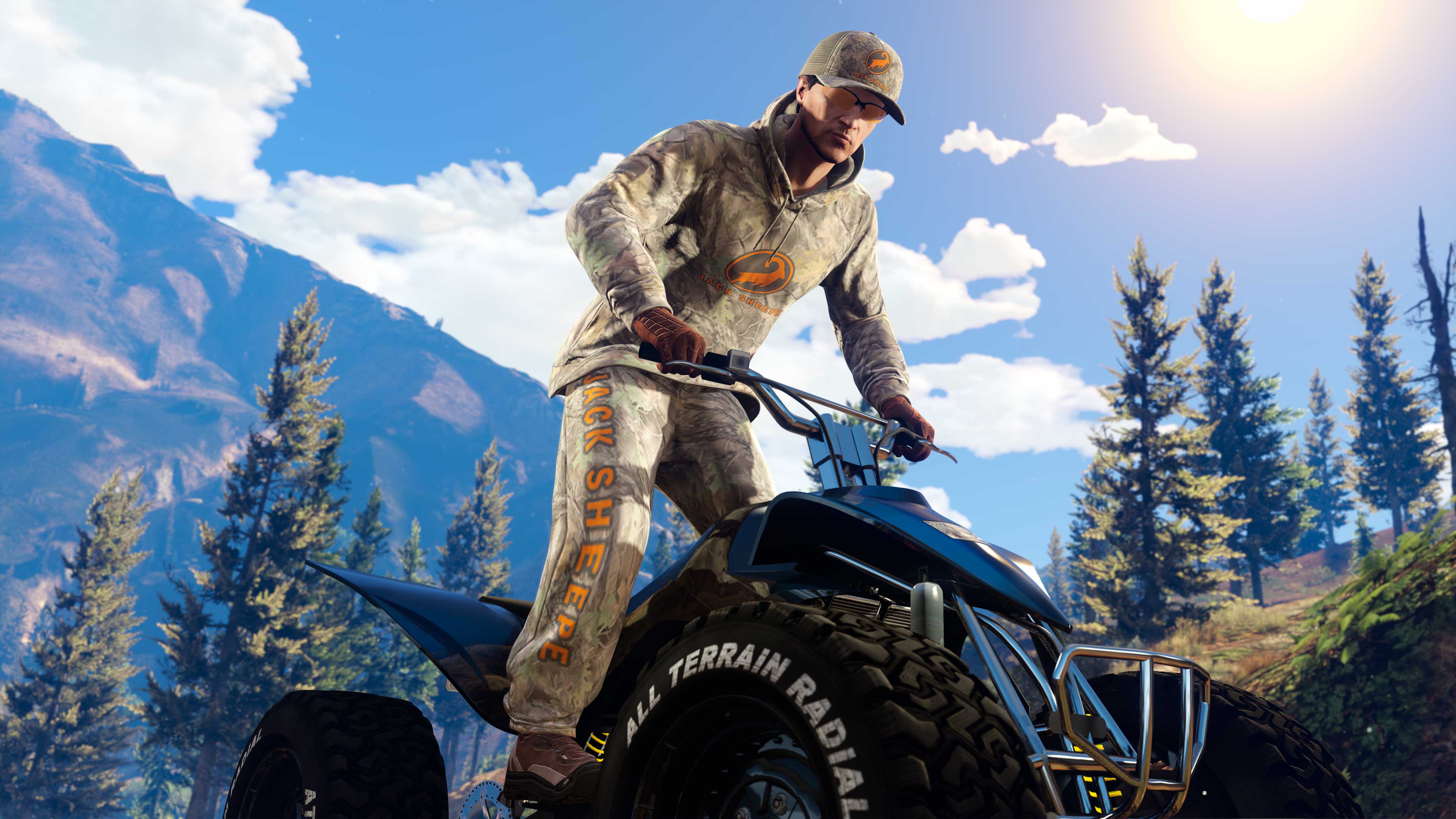 Driving an ATV through a forest scene, a GTA Online character wears the Camo Jack Sheepe Cap, Hoodie, and Track Pants 