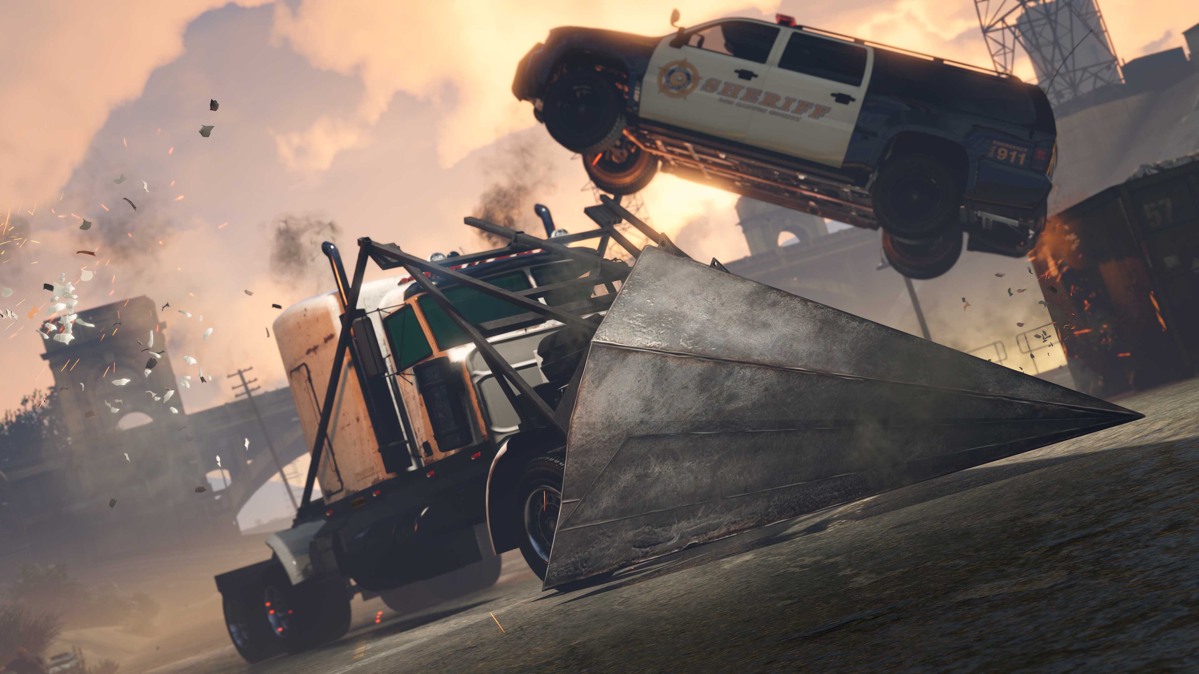 A truck with a large ramped scoop attached to the front drives into a police SUV sending it into the air.