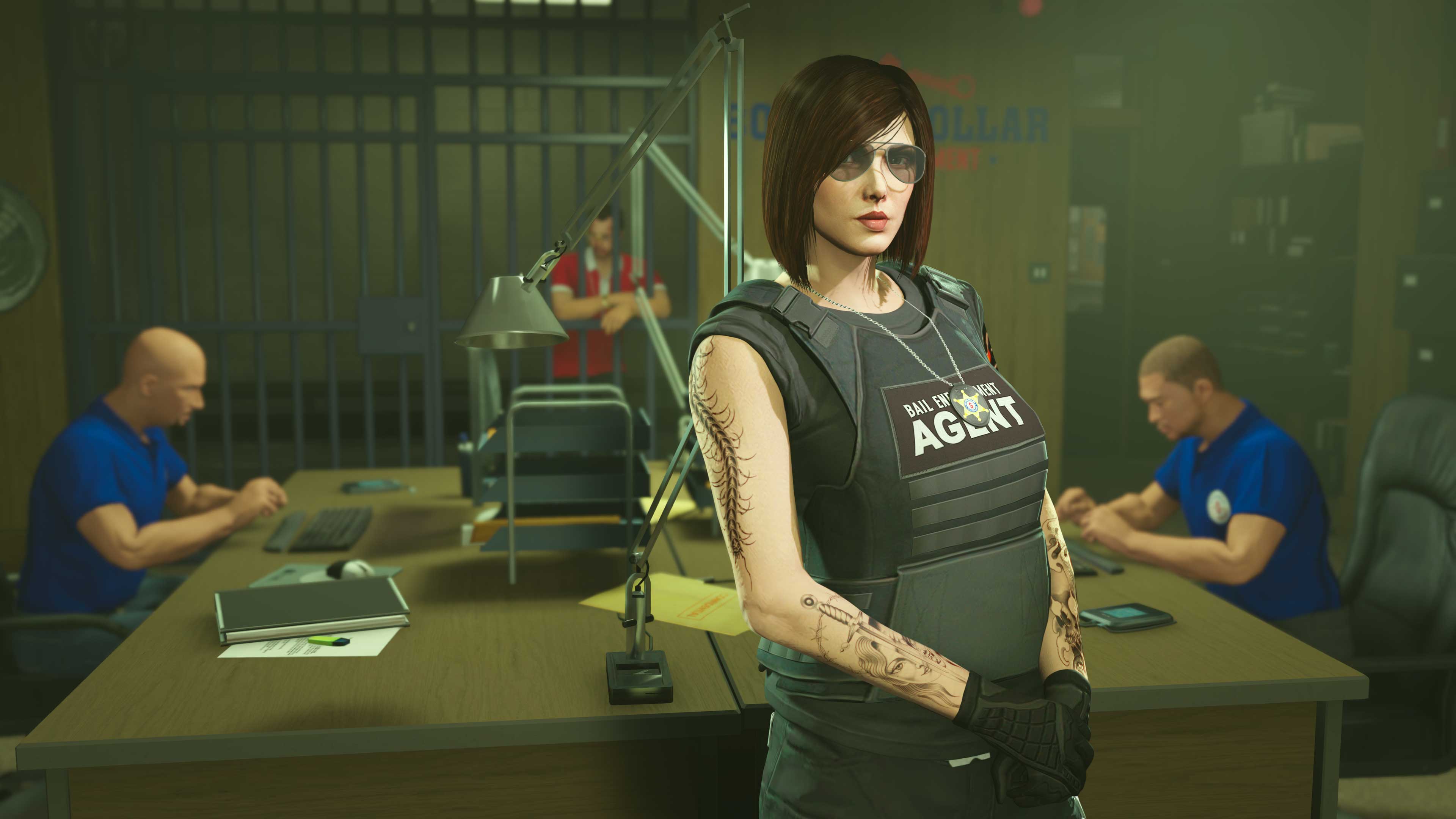A GTA Online character wearing a Bail Enforcement Agent vest stands at a desk where two characters are working.