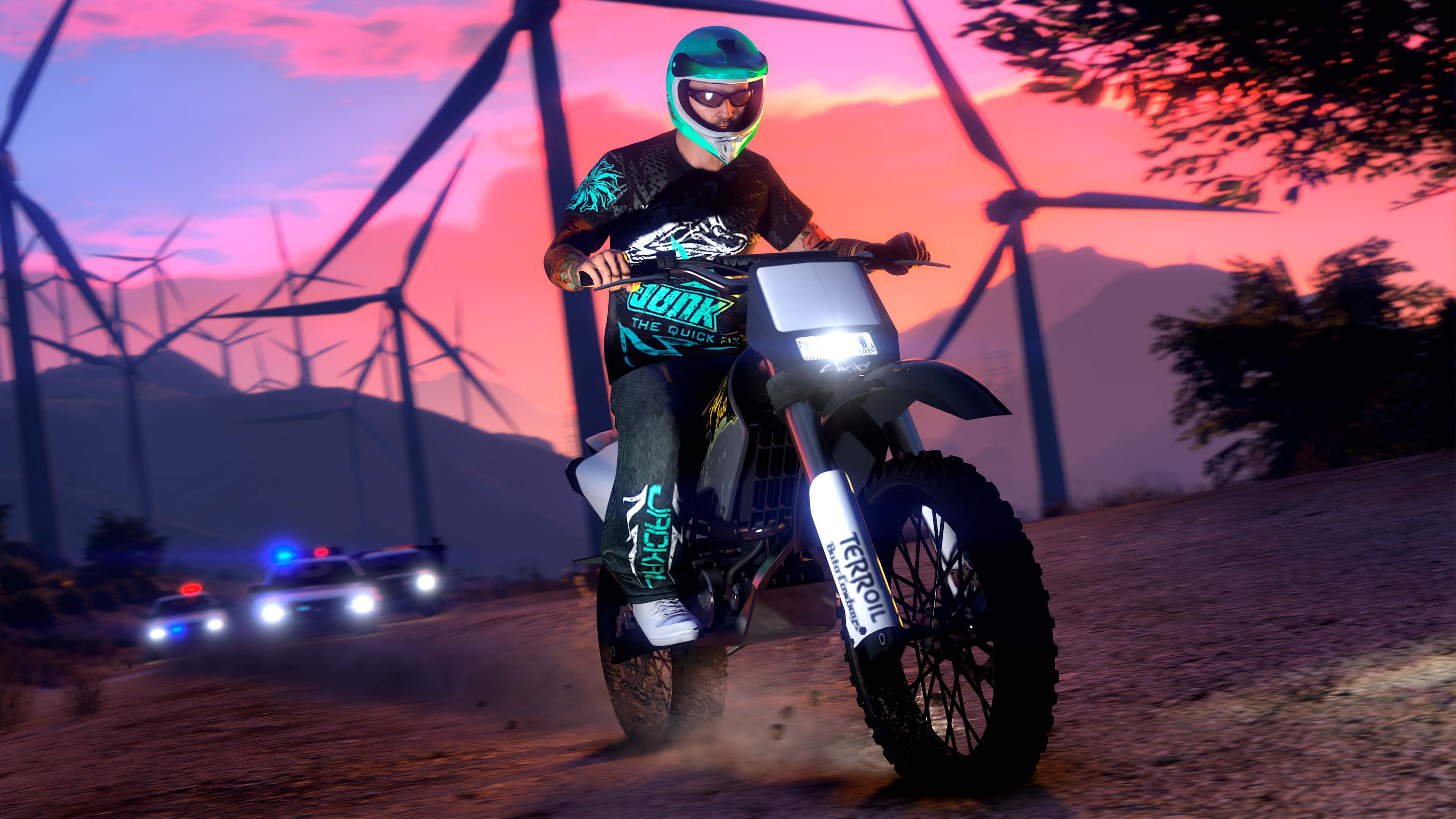 A GTA Online character wears the Junk x Jackal Apparel while riding an off-road motorcycle away from the cops. 