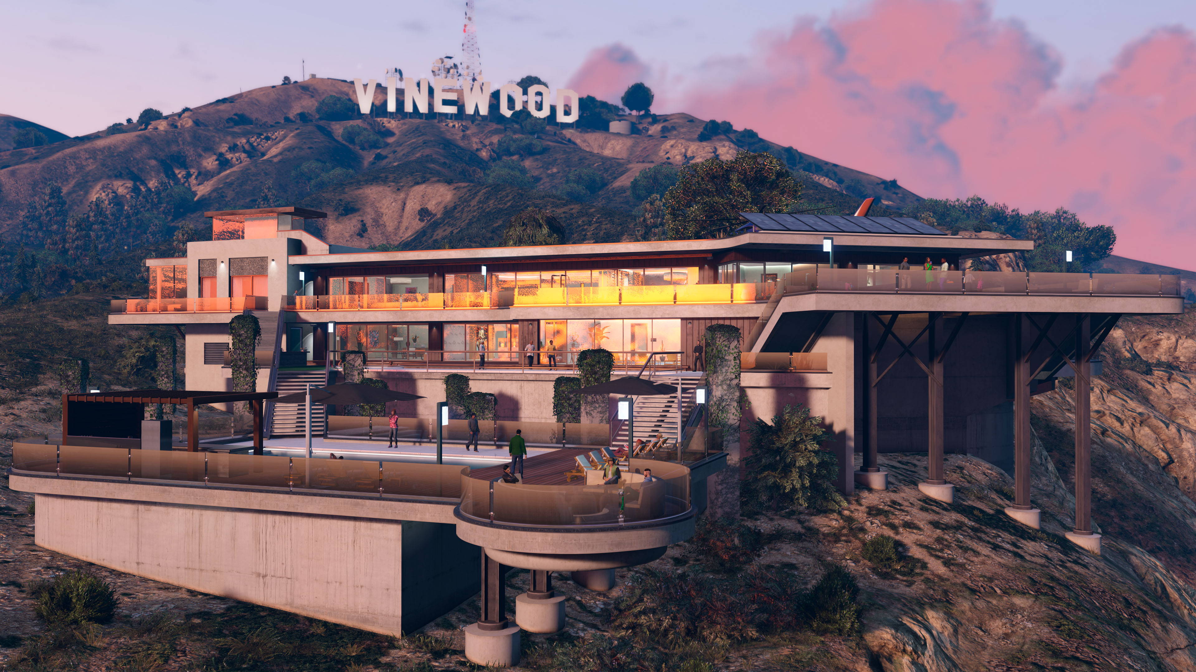 The Vinewood Residence luxury estate below the Vinewood sign in the hills. A large pool and hot tub are nested into the side of the building’s foundations with glass barriers along the walkways and neutral-colored walls. 